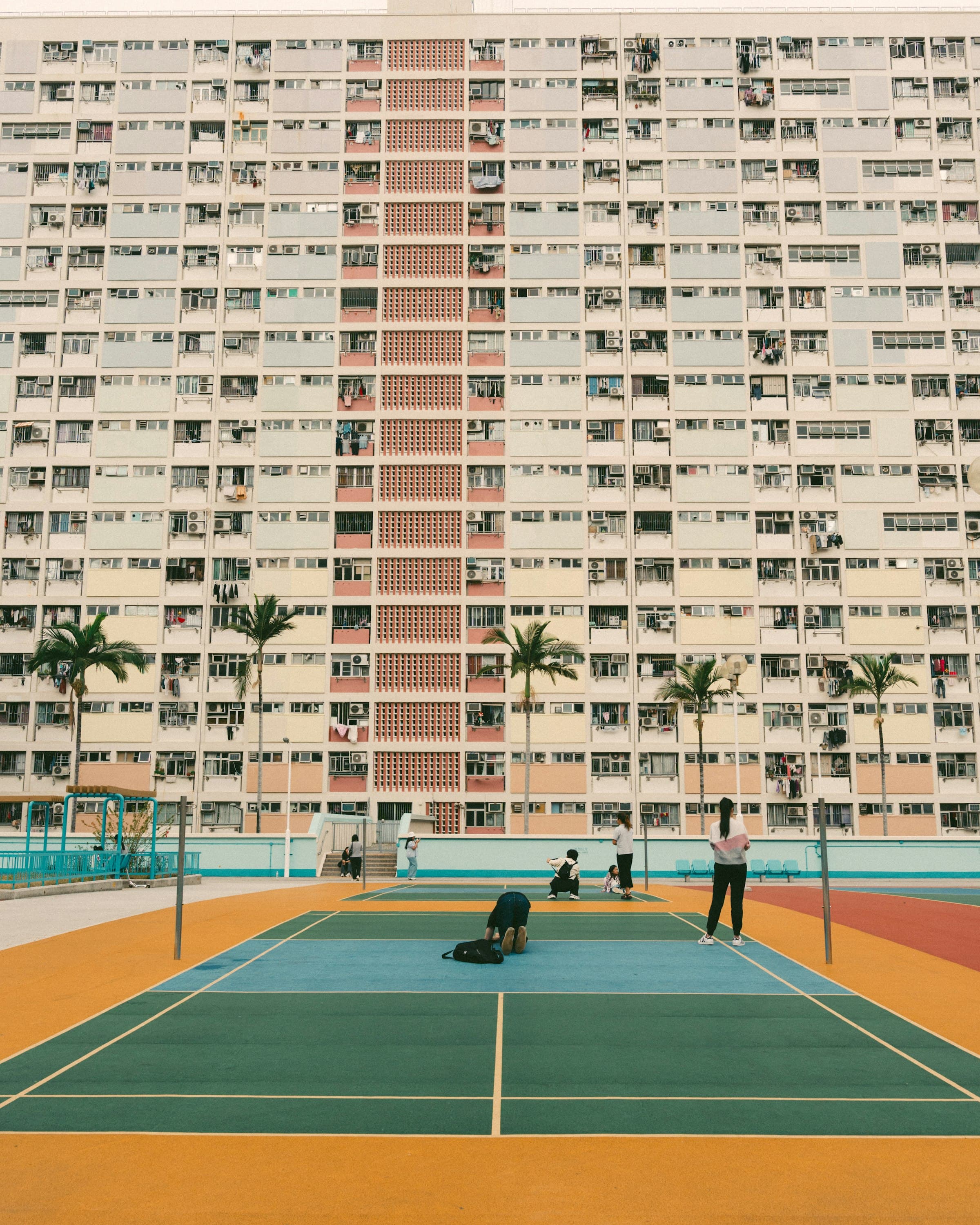 A colourful badminton court in front of a residential tower